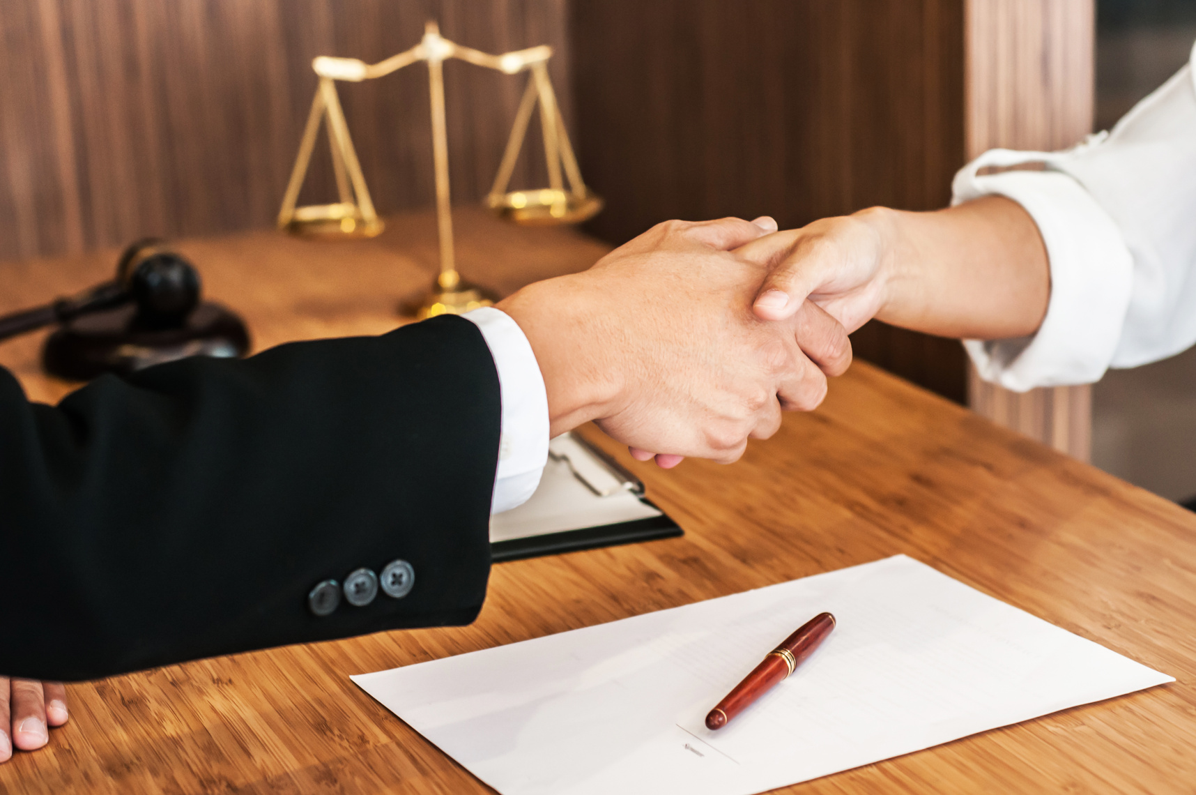 Lawyer consultant shaking hand with client in law firm